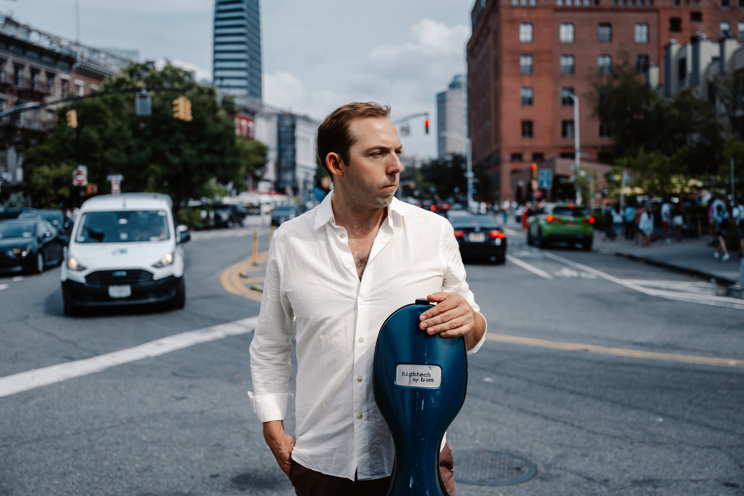 Brook Speltz, concert cellist, photographed on a New York City street with his cello case.